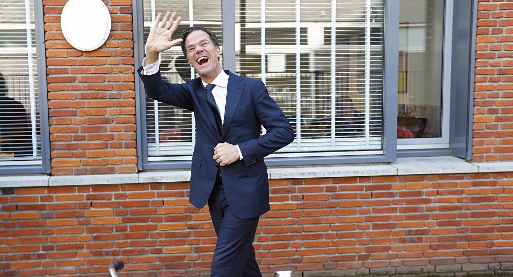 بالفيديو : رئیس وزراء هولندا ينظف مدخل البرلمان بعد سقوط المشروب من يده